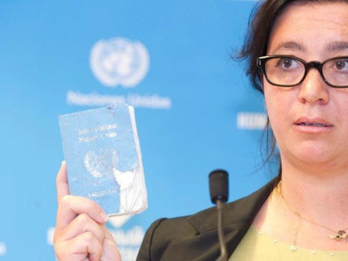 Elpida Rouka holds up bombed UN passport